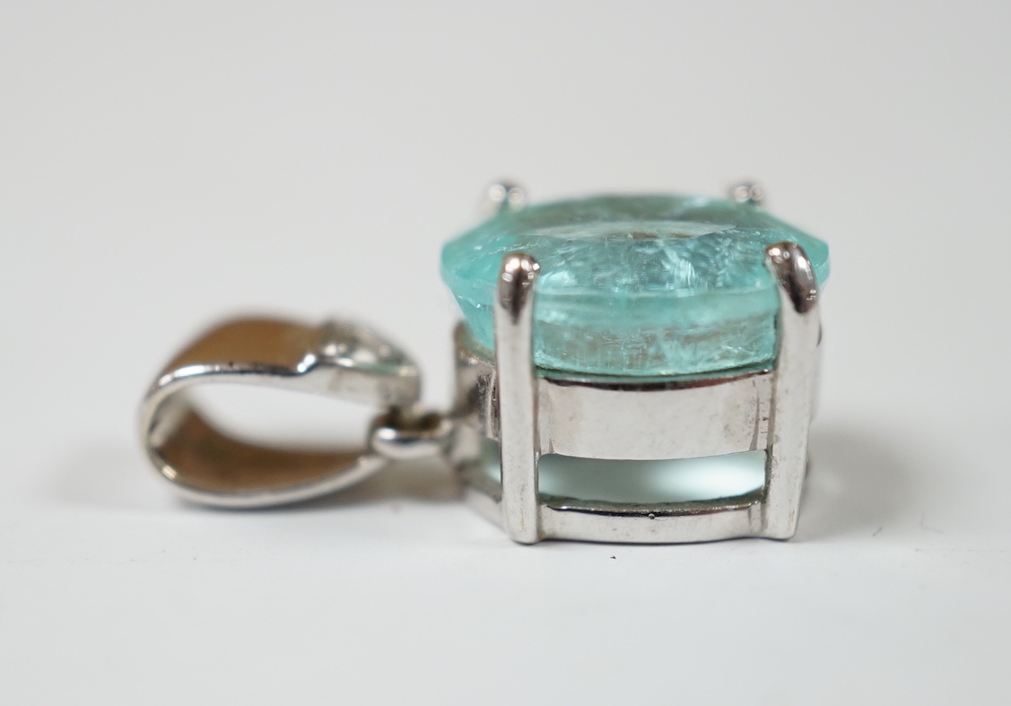An 18ct white gold and single stone oval cut paraiba tourmaline pendant, with single stone diamond set bale, overall 19mm, gross weight 3.7 grams.